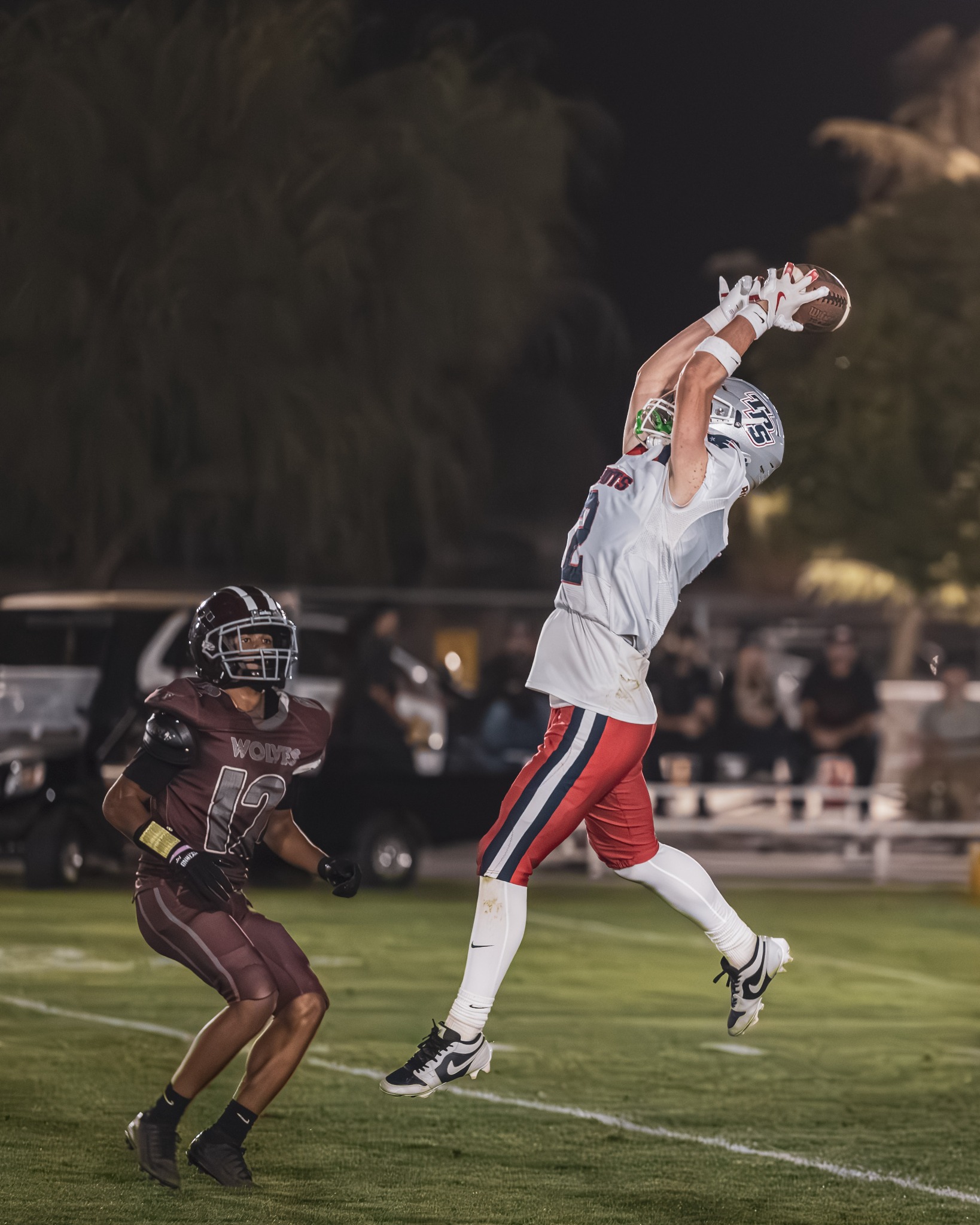 Football player making a leaping catch at night