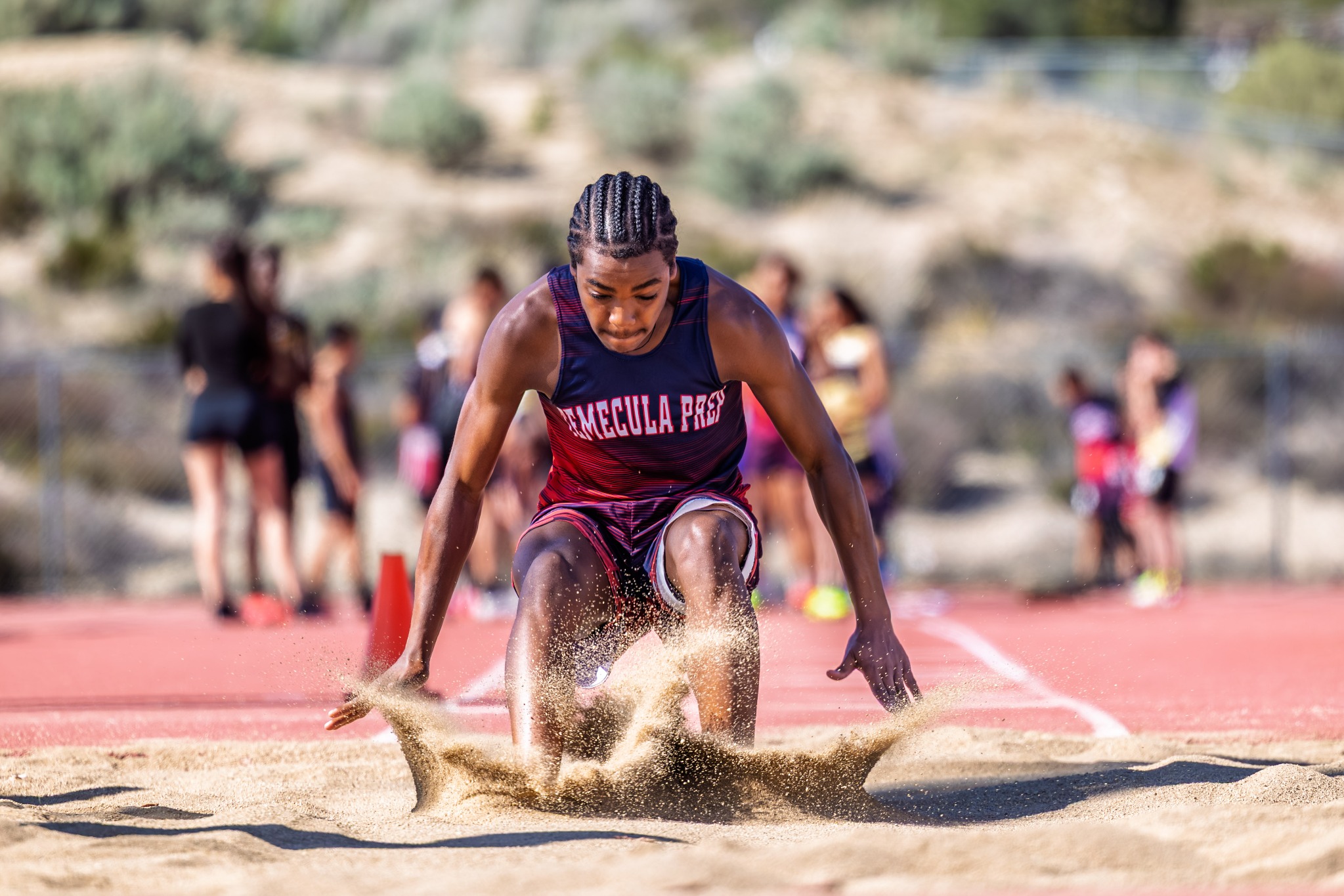 Track and field athlete landing in the long jump pit
