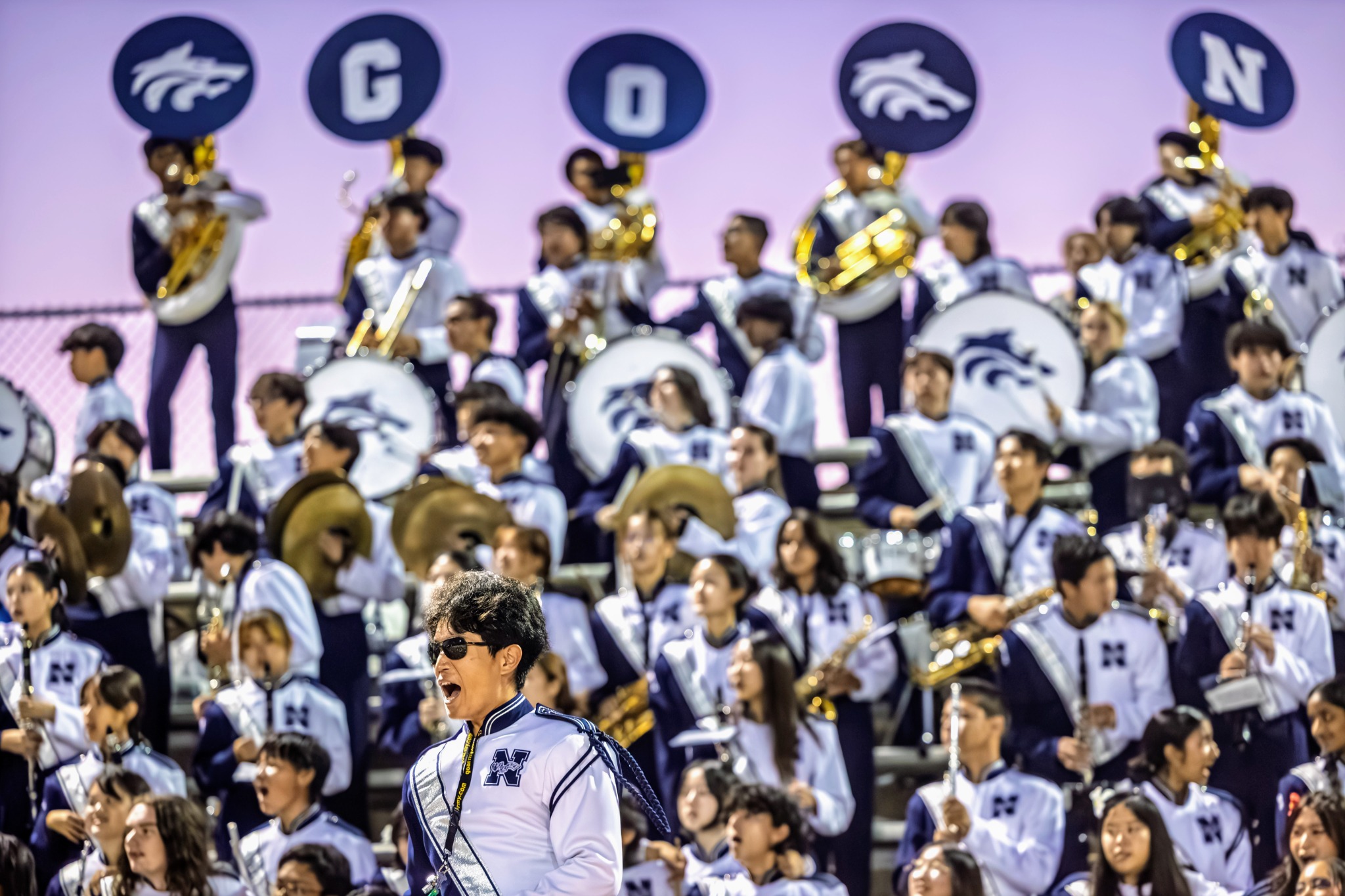 Band conductor in front of marching band